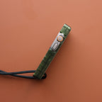 Side profile of an olive green miniPhone Ultra case showing the Apple Watch Ultra crown and side button.